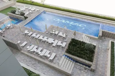 an overhead view of a swimming pool with white chairs and a pool at Business Bay Gem1 bd apt with Scenic Canal Views in Dubai