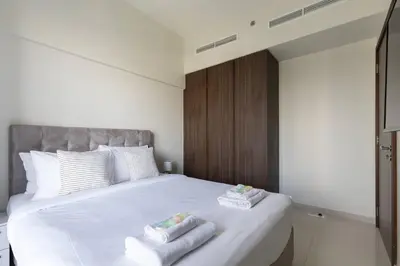 a bedroom with a white bed with towels on it at Business Bay Gem1 bd apt with Scenic Canal Views in Dubai