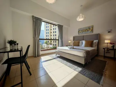 a bedroom with a bed and a large window at Spacious 2BR Apt on JBR Beach near Mall & Metro By La Buena Vida Holiday Homes in Dubai