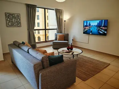a living room with a couch and a tv at Spacious 2BR Apt on JBR Beach near Mall & Metro By La Buena Vida Holiday Homes in Dubai