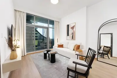 a white living room with a white couch and chairs at Luxe Living in our Exquisite 1 Bedroom Apartment in Dubai