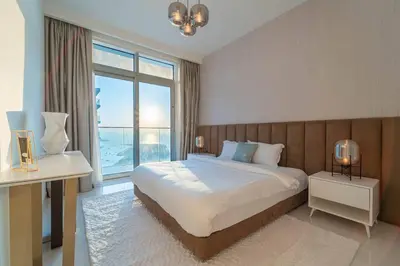 a bedroom with a large bed and a large window at FIRST CLASS 3BR with Dubai Marina & Palm View in Dubai