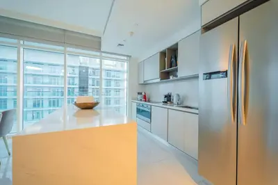 a kitchen with white cabinets and a yellow refrigerator at FIRST CLASS 3BR with Dubai Marina & Palm View in Dubai