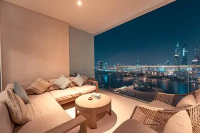 a living room with a couch and a view of a city at FIRST CLASS 3BR with Dubai Marina & Palm View in Dubai