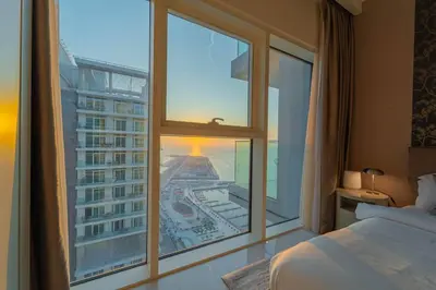 a bedroom with a large window with a view of a city at FIRST CLASS 3BR with Dubai Marina & Palm View in Dubai