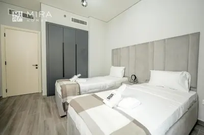 two beds in a hotel room with white at Mira Holiday Homes - Spacious 2 bedroom in Midtown in Dubai