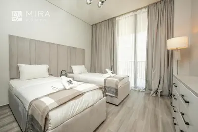 a hotel room with two beds and a window at Mira Holiday Homes - Spacious 2 bedroom in Midtown in Dubai