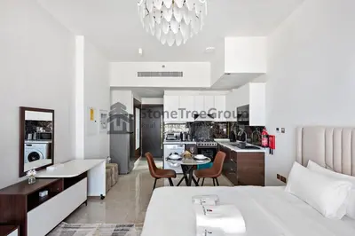 a bedroom with a large bed and a kitchen at StoneTree - Brand New Studio in Jewelz Residence in Dubai