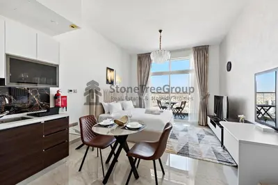 a kitchen and living room with a table and chairs at StoneTree - Brand New Studio in Jewelz Residence in Dubai