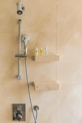 a shower in a bathroom with wooden shelves at Seaview & Marina View Studio in Dubai