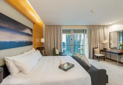a hotel room with a large bed and a desk at Kempinski Central Avenue Residence - Direct Access Dubai Mall in Dubai
