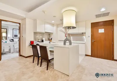 a kitchen with a table and two chairs and a counter at Kempinski Central Avenue Residence - Direct Access Dubai Mall in Dubai