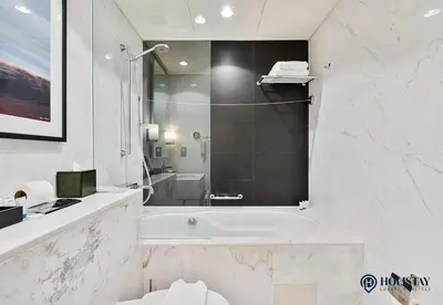 a white bathroom with a tub and a shower at Kempinski Central Avenue Residence - Direct Access Dubai Mall in Dubai