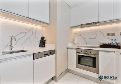 a kitchen with white cabinets and a sink at Kempinski Central Avenue Residence - Direct Access Dubai Mall in Dubai