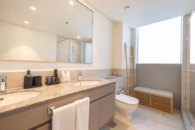 a bathroom with two sinks and a toilet and a mirror at Daniels Luxury 3BR with Dubai Opera Views in Dubai