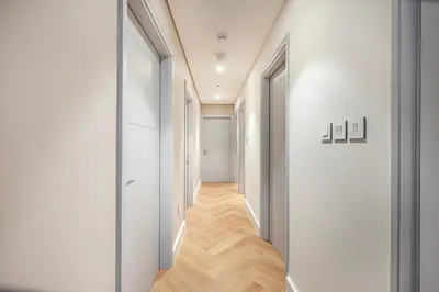 a hallway with white walls and wooden floors at Daniels Luxury 3BR with Dubai Opera Views in Dubai