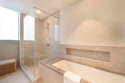 a bathroom with a tub and a glass shower at Daniels Luxury 3BR with Dubai Opera Views in Dubai