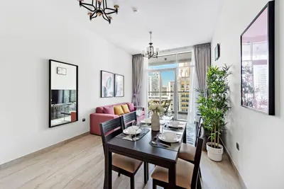 a dining room and living room with a table and chairs at StoneTree - Elegant 1BR with Stunning View of Marina in Dubai