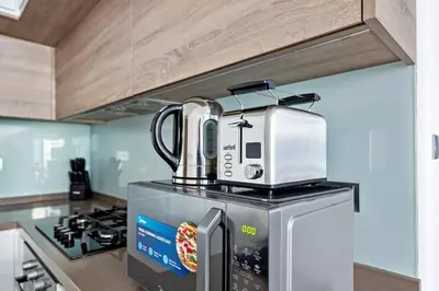 a microwave sitting on top of a refrigerator in a kitchen at StoneTree - Elegant 1BR with Stunning View of Marina in Dubai