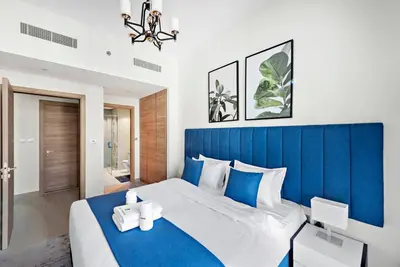 a blue and white bedroom with a large bed at StoneTree - Elegant 1BR with Stunning View of Marina in Dubai