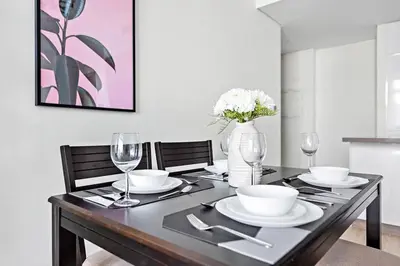 a dining room table with a vase of flowers on it at StoneTree - Elegant 1BR with Stunning View of Marina in Dubai