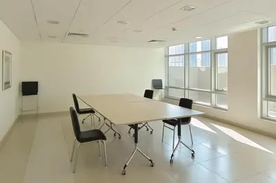 an office meeting room with a table and chairs at Close to Metro - Classic 2BR in Loft East,Downtown in Dubai