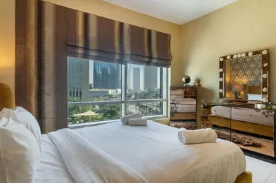 a bedroom with a large bed with a large window at Close to Metro - Classic 2BR in Loft East,Downtown in Dubai