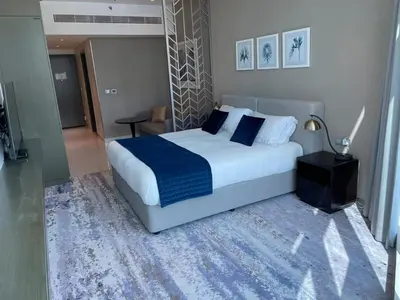 a bedroom with a large bed with a blue blanket at Damac Prive l Canal View l Great Location in Dubai
