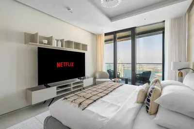 a bedroom with a large bed with a tv on the wall at GuestReady - Sky-High Dubai Dreamscape in Dubai