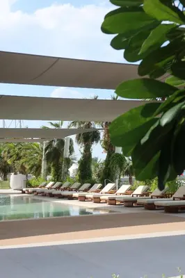 a row of lounge chairs next to a swimming pool at LUXSeaside/2BD/LaVie/JBR in Dubai