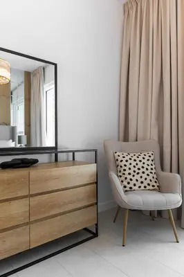 a room with a dresser and a chair and a mirror at LUXSeaside/2BD/LaVie/JBR in Dubai