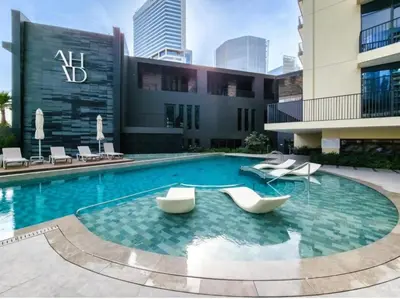 a swimming pool with two chairs and a building at GuestReady - A fantastic home in Business Bay in Dubai