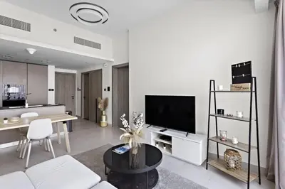 a living room with a couch and a television at Cosy 1BR in the center of JVC in Dubai