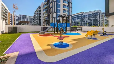 a playground with a slide in a city at Frank Porter - Riviera 27 in Dubai