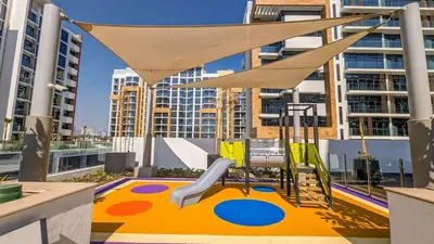 a play area with a playground with a swing at Frank Porter - Riviera 27 in Dubai