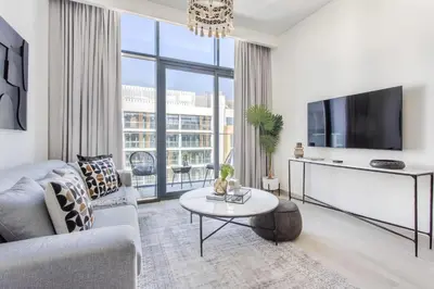 a living room with a couch and a tv and a table at Frank Porter - Riviera 27 in Dubai