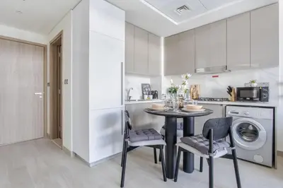 a kitchen with a table and chairs in a room at Frank Porter - Riviera 27 in Dubai