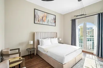 a bedroom with a bed and a large window at Luxury 1 Bedroom Apartment in Discovery Gardens in Dubai