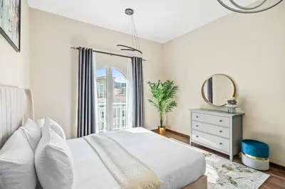 a bedroom with a white bed and a mirror at Luxury 1 Bedroom Apartment in Discovery Gardens in Dubai