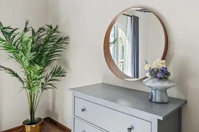 a mirror on top of a dresser with a plant at Luxury 1 Bedroom Apartment in Discovery Gardens in Dubai