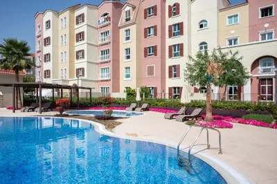 a swimming pool in front of a large building at Luxury 1 Bedroom Apartment in Discovery Gardens in Dubai