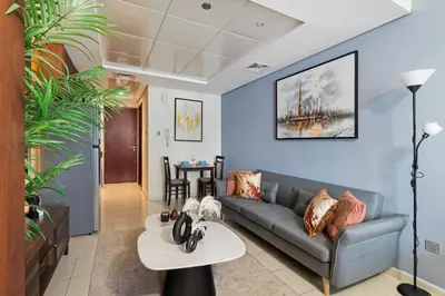 a living room with a couch and a table at Modern JLT Studio Lake View 5min MetroMarina in Dubai