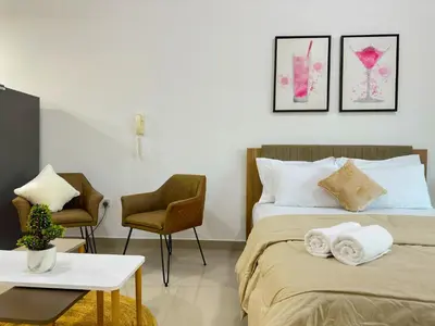 a bedroom with a bed and two chairs and a table at 35% OFF in Top View Studio w/ Balcony in Marina in Dubai