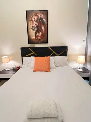 a bedroom with a large white bed with two lamps at Dream Tower 1 in Dubai