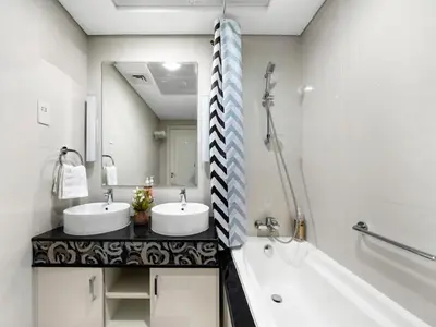 a bathroom with two sinks and a tub and a mirror at Elegant 1BR in Downtown, Close to Dubai Mall in Dubai