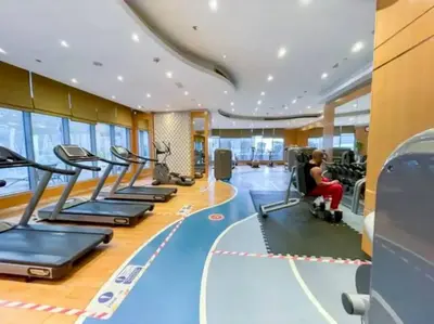 a gym with a woman in a wheelchair in a gym at Elegant 1BR in Downtown, Close to Dubai Mall in Dubai