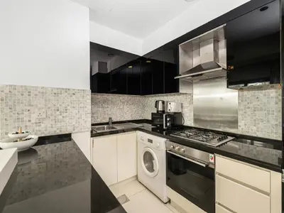 a kitchen with a stove and a washer and dryer at Elegant 1BR in Downtown, Close to Dubai Mall in Dubai