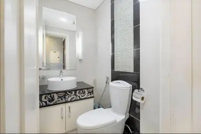 a white bathroom with a toilet and a sink at Elegant 1BR in Downtown, Close to Dubai Mall in Dubai