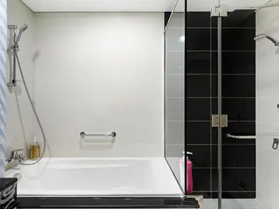 a bathroom with a shower with a white tub at Elegant 1BR in Downtown, Close to Dubai Mall in Dubai