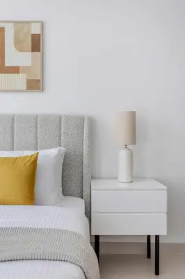 a bedroom with a bed and a nightstand with a lamp at Frank Porter - The Grand in Dubai